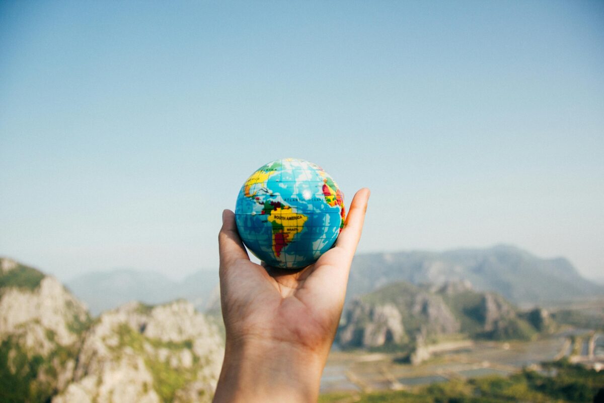 an Hand holding a small earth globe