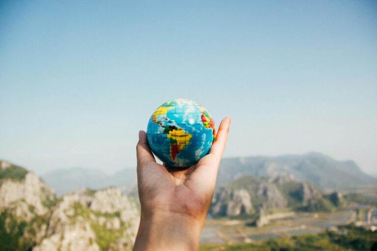 an Hand holding a small earth globe