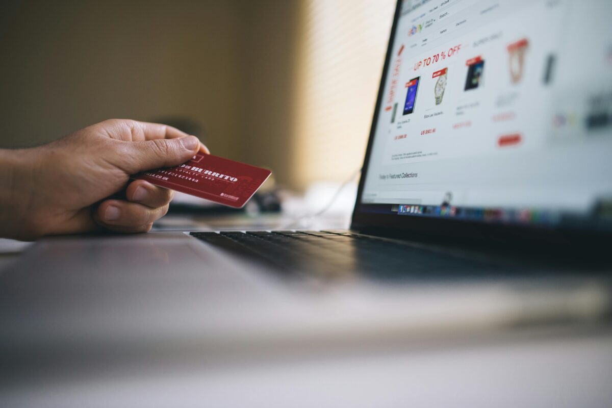 Close up of laptop and hand with credit card.