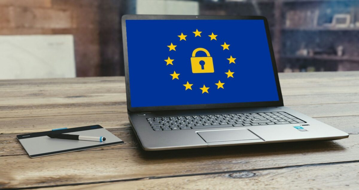 a Laptop on a desk with some European security graphic