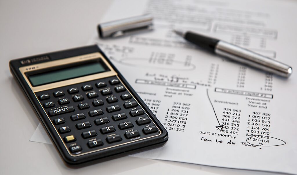 Calculator with a financial overview and a pen.